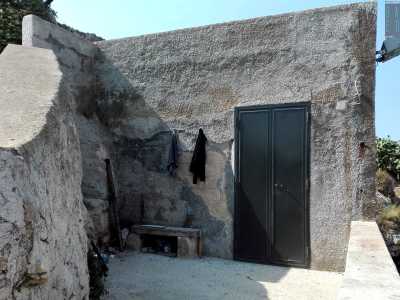 Prima di raggiungere la riva notiamo sulla sinistra una piccola dimora in pietra affacciata sul mare, il cui unico elemento esteriore � una porta in ferro, accanto a cui sono appesi alcuni ritagli di stoffa